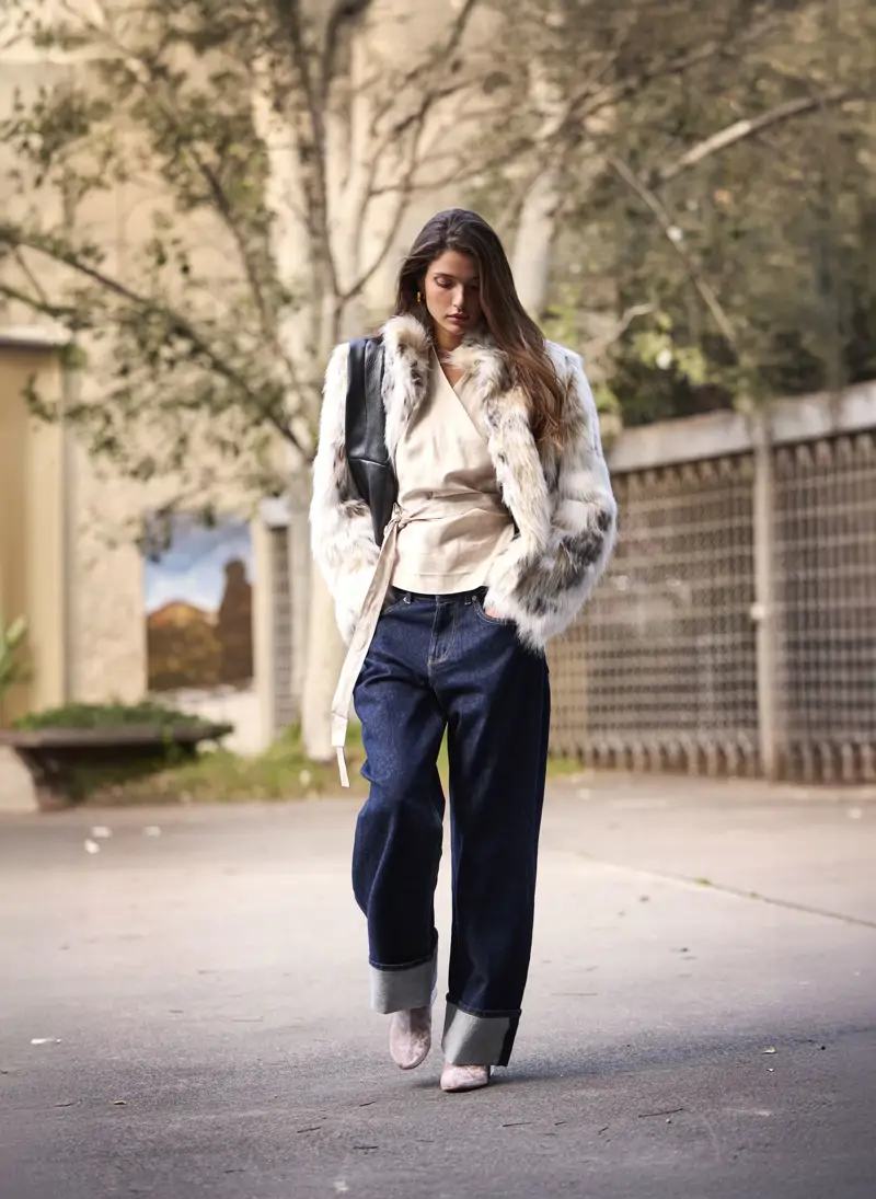 Jean large taille basse porté avec manteau oversize pour un look tendance équilibré.